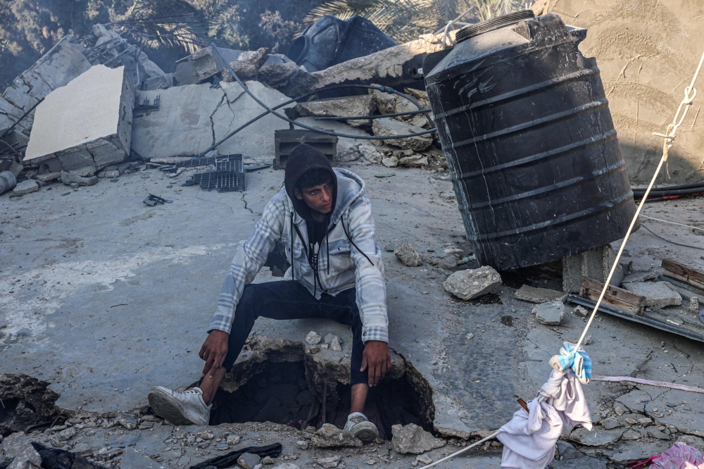 Palestinians search the rubble of their house destroyed in an overnight Israeli air strike in east Khan Yunis in the southern Gaza Strip February 26, 2024. — AFP pic