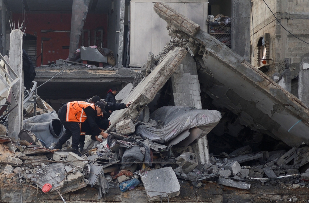 Palestinians inspect the site of an Israeli strike on a house, amid the ongoing conflict between Israel and the Palestinian Islamist group Hamas, in Rafah in the southern Gaza Strip February 27, 2024. — Reuters pic