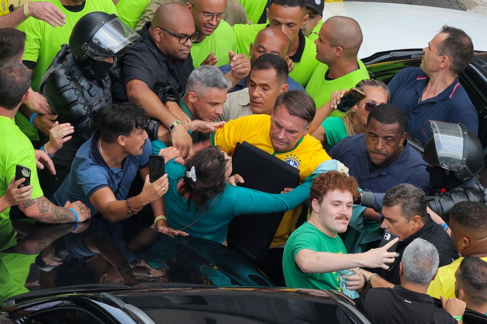 Brazil's former president Jair Bolsonaro leaves while his supporters gather on Paulista Avenue, as police investigate him and his cabinet for allegedly plotting a coup after the 2022 election, in Sao Paulo, Brazil, February 25, 2024. — Reuters pic