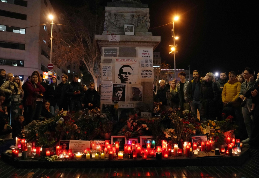 People gather around at a makeshift memorial to pay tribute to the Russian opposition leader Alexei Navalny in Barcelona on March 1, 2024. — AFP pic