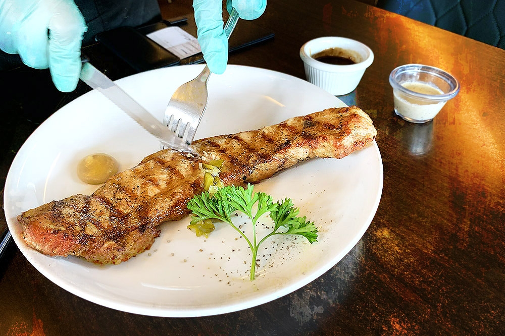 Fantastic table service: A staff member helping to slice the Sakura pork belly.