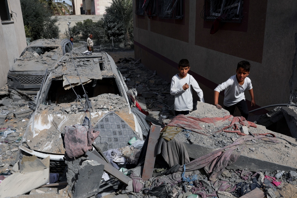 Children stand near a damaged vehicle at the site of an Israeli strike on a house, amid the ongoing conflict between Israel and Hamas, in Rafah in the southern Gaza Strip, March 1, 2024. ― Reuters pic