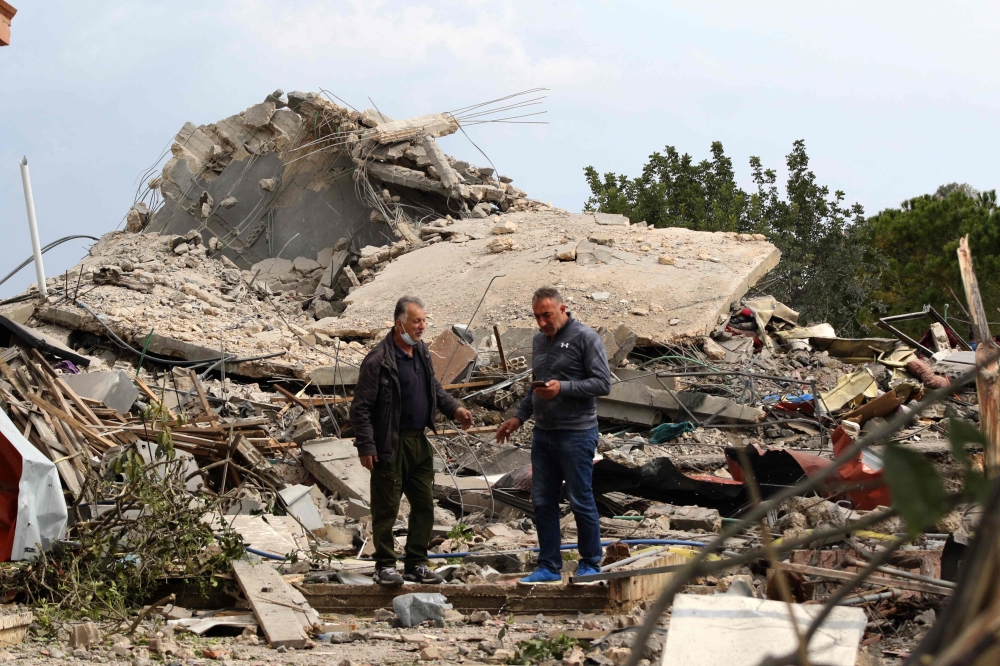 Men checking the site of an Israeli air strike that targeted a house in the southern Lebanese village of Jibshit on February 27, 2024. — AFP pic
