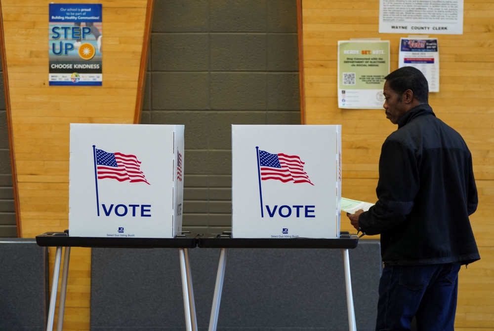 File photo of a man going behind a voting booth as Democrats and Republicans hold their Michigan primary presidential election, in Detroit, Michigan, US February 27, 2024. — Reuters pic
