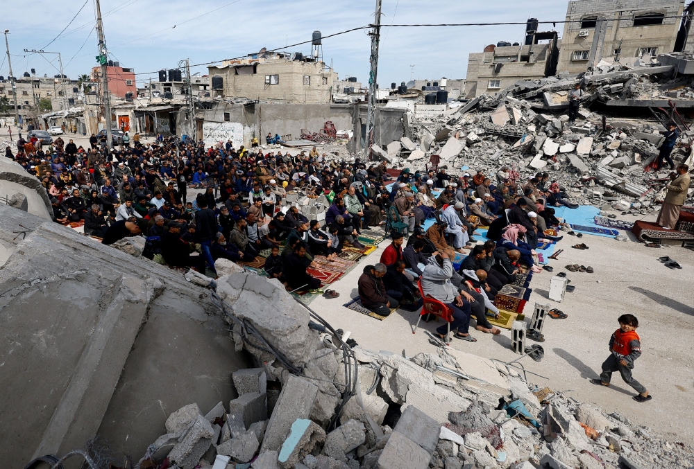 Palestinians attend Friday prayers near the ruins of a mosque destroyed in Israeli strikes, amid the ongoing conflict between Israel and Hamas, in Rafah in the southern Gaza Strip March 1, 2024. — Reuters pic