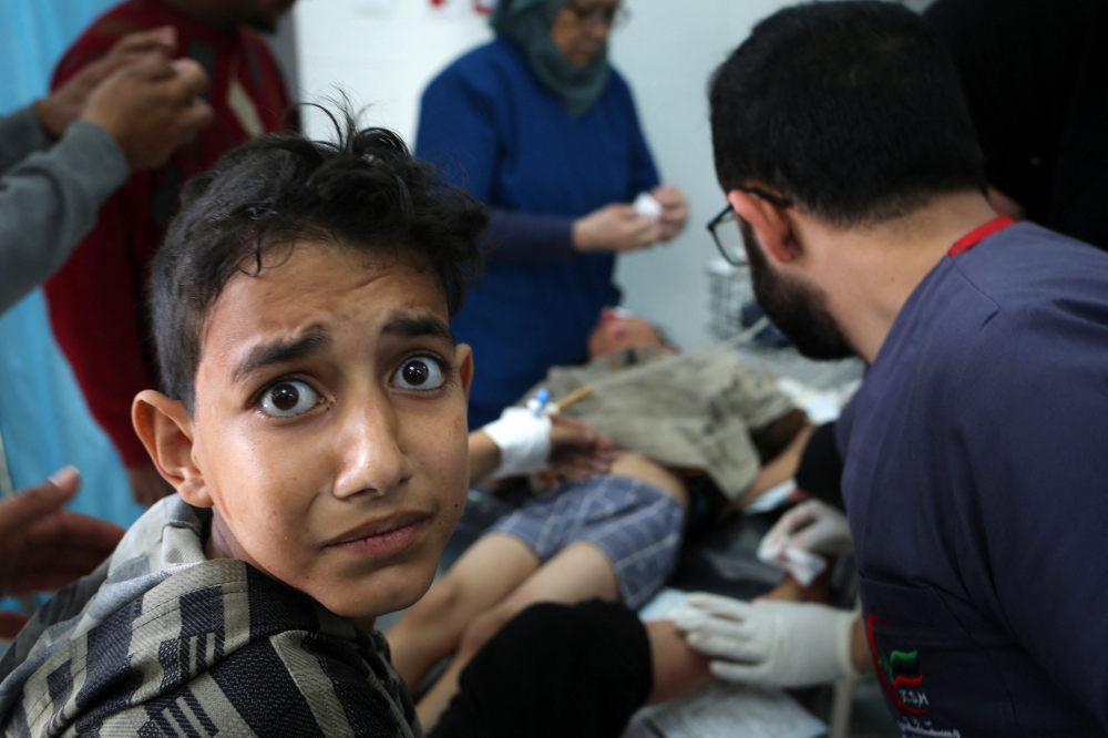 A young boy reacts as a child receives medical attention at the Kuwaiti hospital for wounds sustained in an Israeli bombardment that hit a camp sheltering displaced Palestinians near the Emirati hospital, in Rafah in the southern Gaza Strip on March 2, 2024, amid the ongoing conflict between Israel and the Hamas movement. — AFP pic