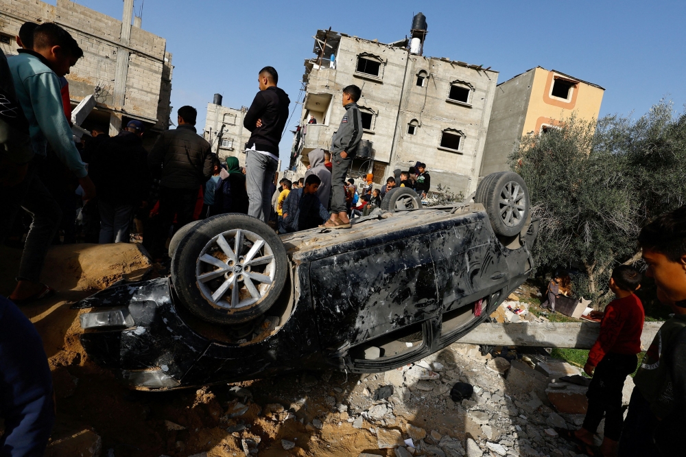 Palestinians gather at the site of an Israeli airstrike in Rafah in the southern Gaza Strip. — Reuters pic