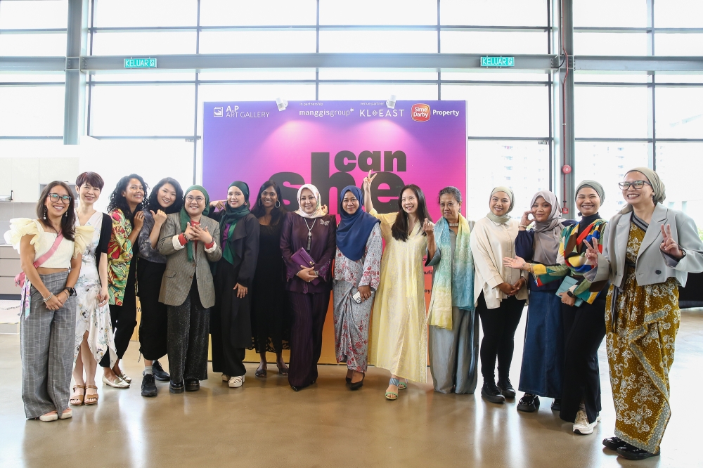 Curator Nazura Rahime (2nd right), Puan Seri Wan Hibatul Hidayah Wan Ismail (8th left) and artists pose for a picture during the opening of Woman's Day art exhibition ‘Can She Do It?'. — Picture by Yusof Mat Isa