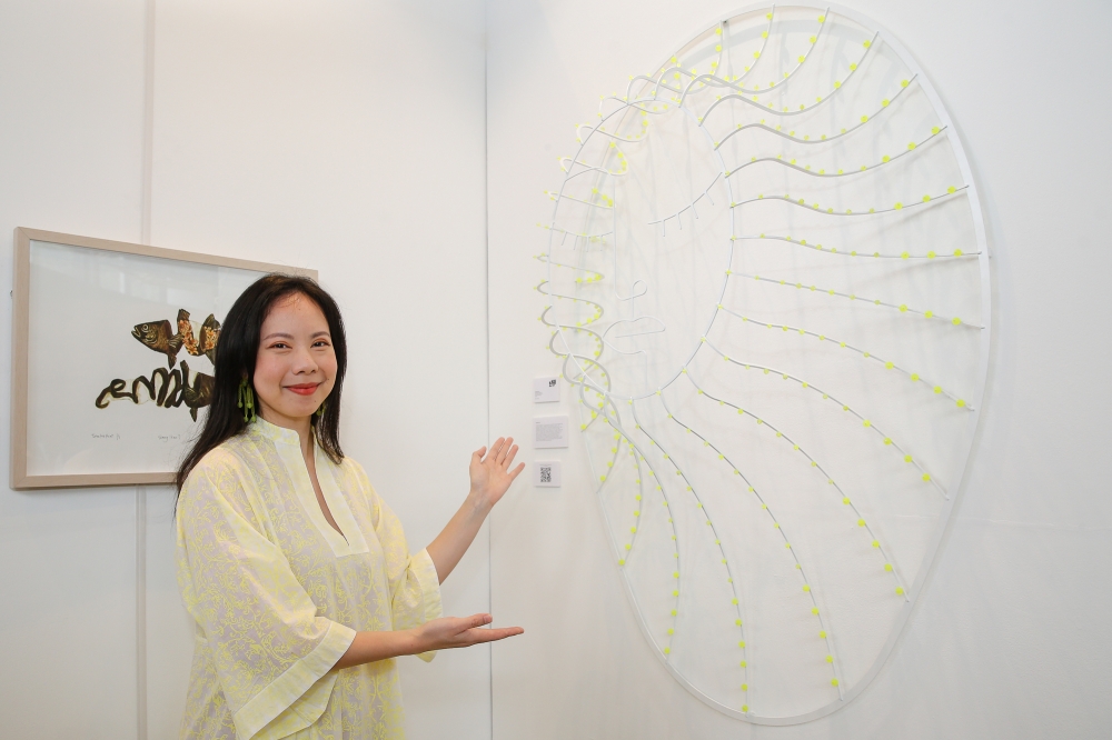Tan and her artwork ‘Veiled Emergence’, one of the works exhibited at 'Can She Do It?'. — Picture by Yusof Mat Isa