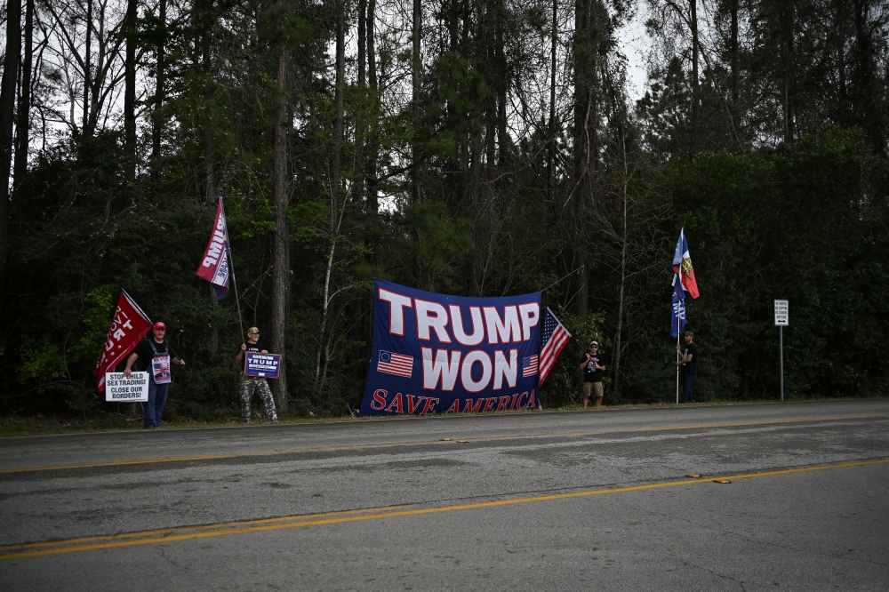 Supporters of Republican presidential candidate and former US President Donald Trump hold signs, near the venue where hosts her campaign event in Houston, Texas March 4, 2024. ― Reuters pic