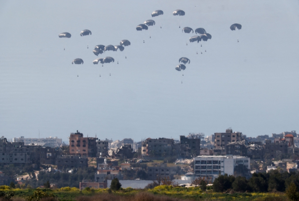 Packages fall towards Gaza, after being dropped from a military aircraft, amid the ongoing conflict between Israel and the Palestinian group Hamas, as seen from Israel's border with Gaza in southern Israel March 5, 2024. — Reuters pic