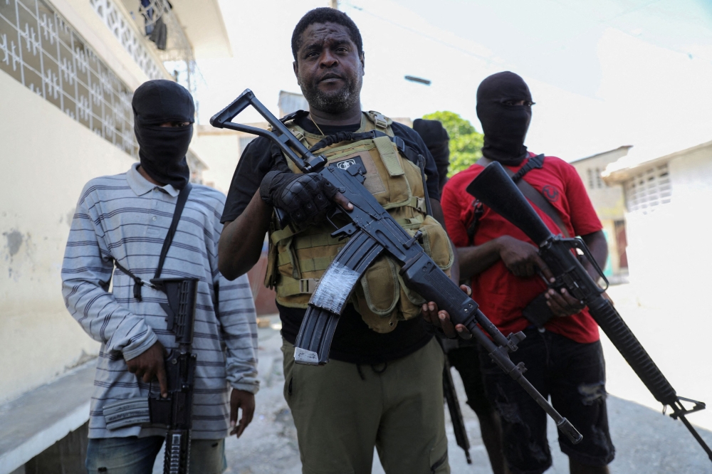 Former police officer Jimmy ‘Barbecue’ Cherizier, leader of the ‘G9’ gang alliance, is flanked by gang members after a press conference in Delmas 6, Port-au-Prince, Haiti March 5, 2024. — Reuters pic