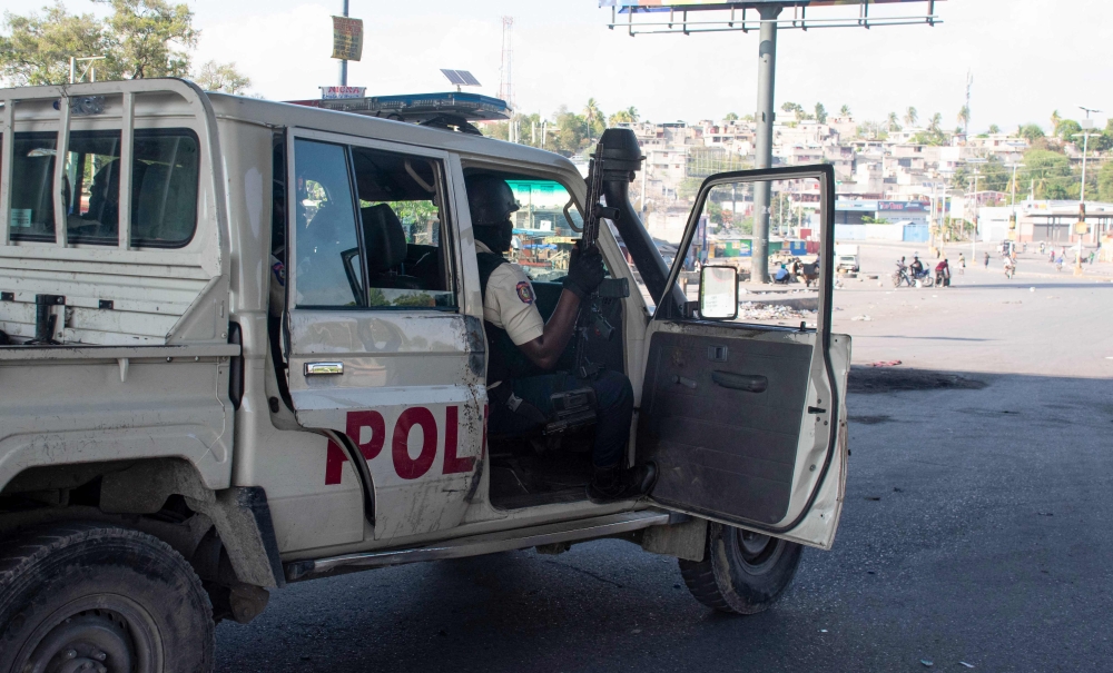 Police officers control the perimeter of the police station, set on fire the previous day by armed gangs, in Port-au-Prince. — AFP pic