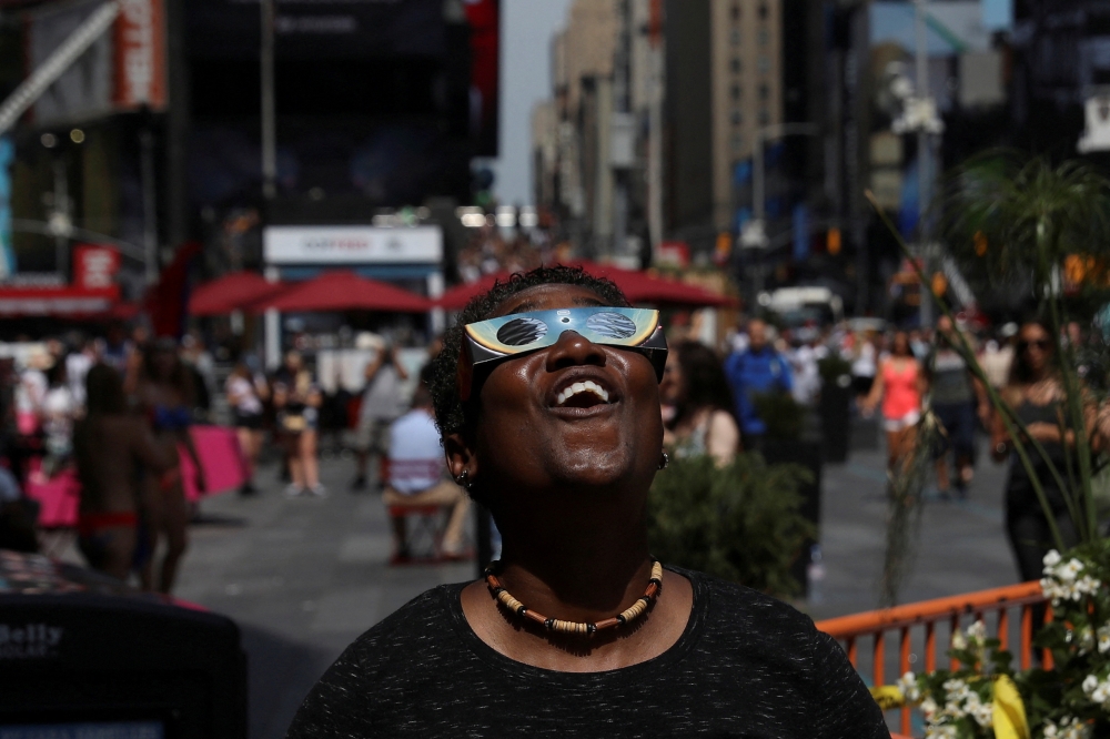 A woman views the solar eclipse at Times Square in Manhattan, New York, US, August 21, 2017.  — Reuters pic 