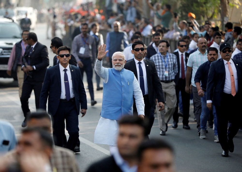 India's Prime Minister Narendra Modi waves to his supporters as he arrives to cast his vote during the second and last phase of Gujarat state assembly elections in Ahmedabad December 5, 2022. — Reuters pic  