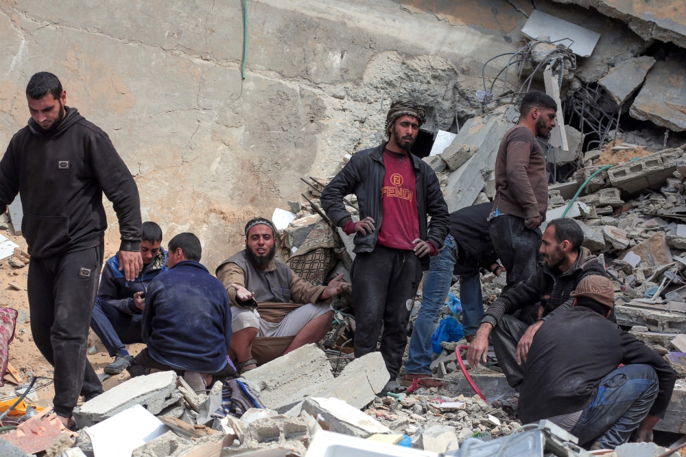 Palestinians inpect the rubble of a building in Deir el-Balah following Israeli bombardment, in the central Gaza Strip, on March 8, 2024, amid ongoing battles between Israel and the militant group Hamas. — AFP pic
