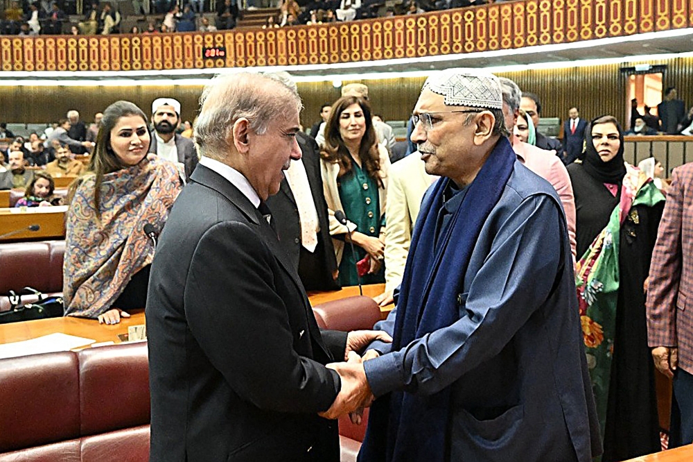 This handout photograph taken and released on March 3, 2024 by the Pakistan National Assembly, shows Pakistan’s former President Asif Ali Zardari (right) greeting newly-elected Pakistan’s Prime Minister Shehbaz Sharif (left) at the Parliament House in Islamabad. — AFP pic