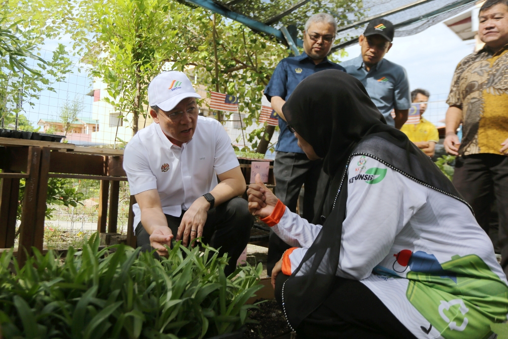 Housing and Local Government Minister Nga Kor Ming looks at vegetables planted with compost soil at the Zero Waste Community Programme at Jalan Hospital flats in Ipoh, March 10, 2024. — Bernama pic 