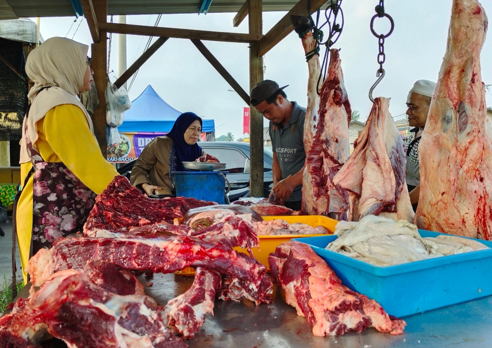 Trader Mohd Shahrulrazi Fauzi attends to customers who buy local beef at his stall in Kampung Chica, Kota Baru, Kelantan, March 10, 2024. — Bernama pic 