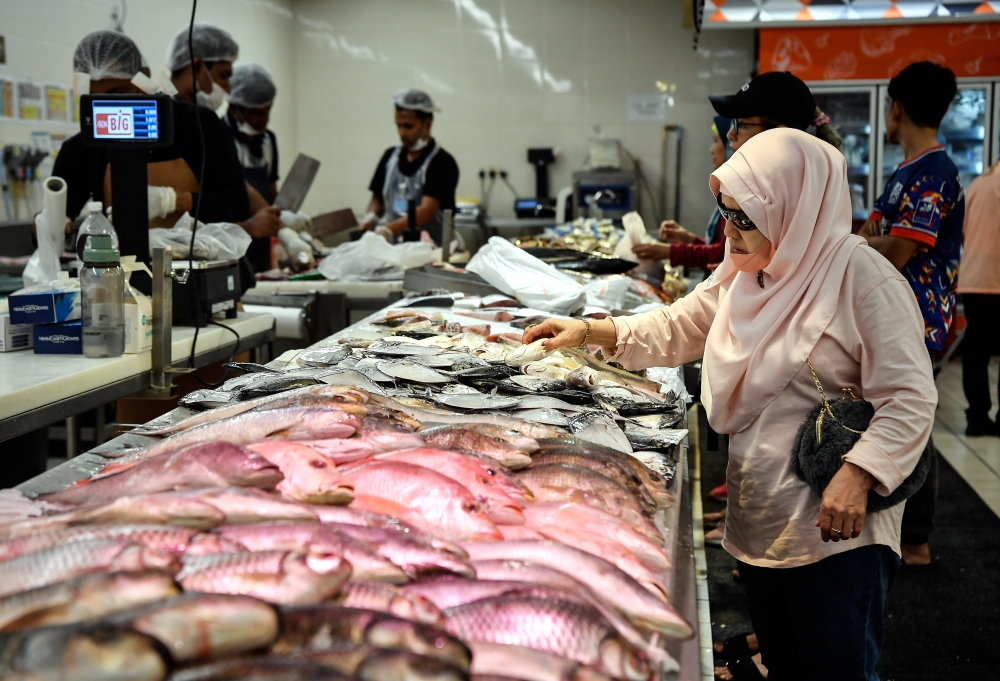A woman buys fish at a supermarket in Kuala Lumpur, March 10, 2024. — Bernama pic 