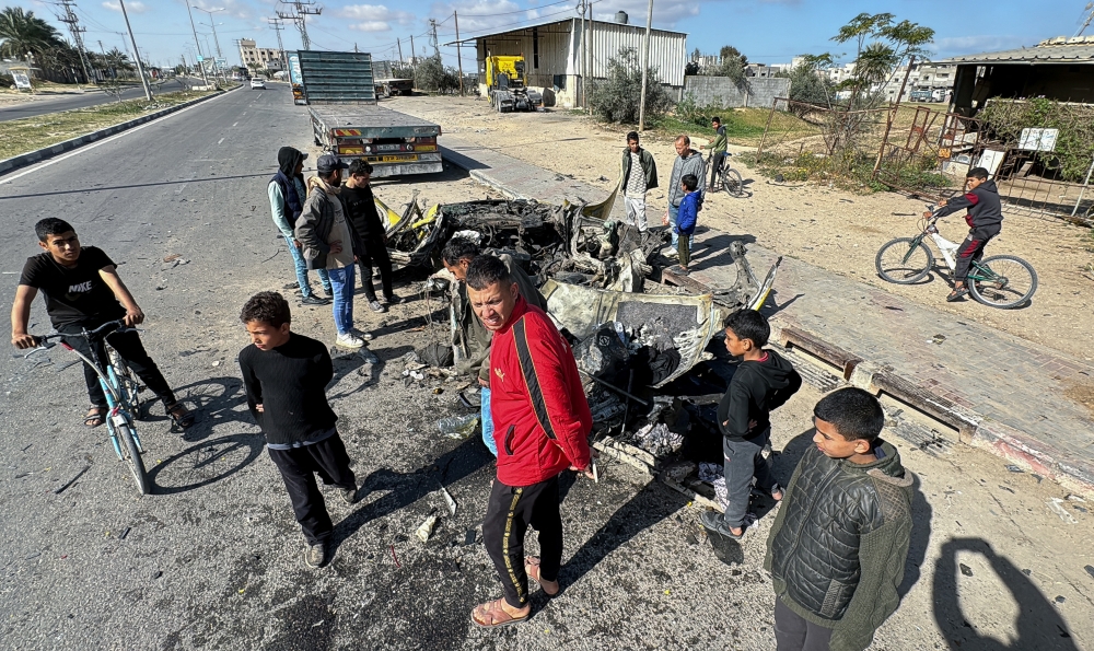 Palestinians gather at the site of an Israeli strike on a car, amid the ongoing conflict between Israel and the Palestinian Islamist group Hamas, in Rafah in the southern Gaza Strip March 10, 2024. — Reuters pic
