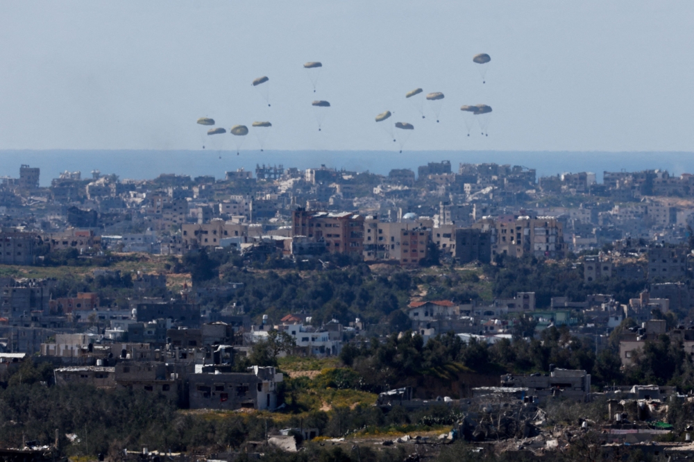 Packages fall towards northern Gaza, after being dropped from a military aircraft, amid the ongoing conflict between Israel and the Palestinian group Hamas, as seen from Israel's border with Gaza, in southern Israel, March 10, 2024. — Reuters pic