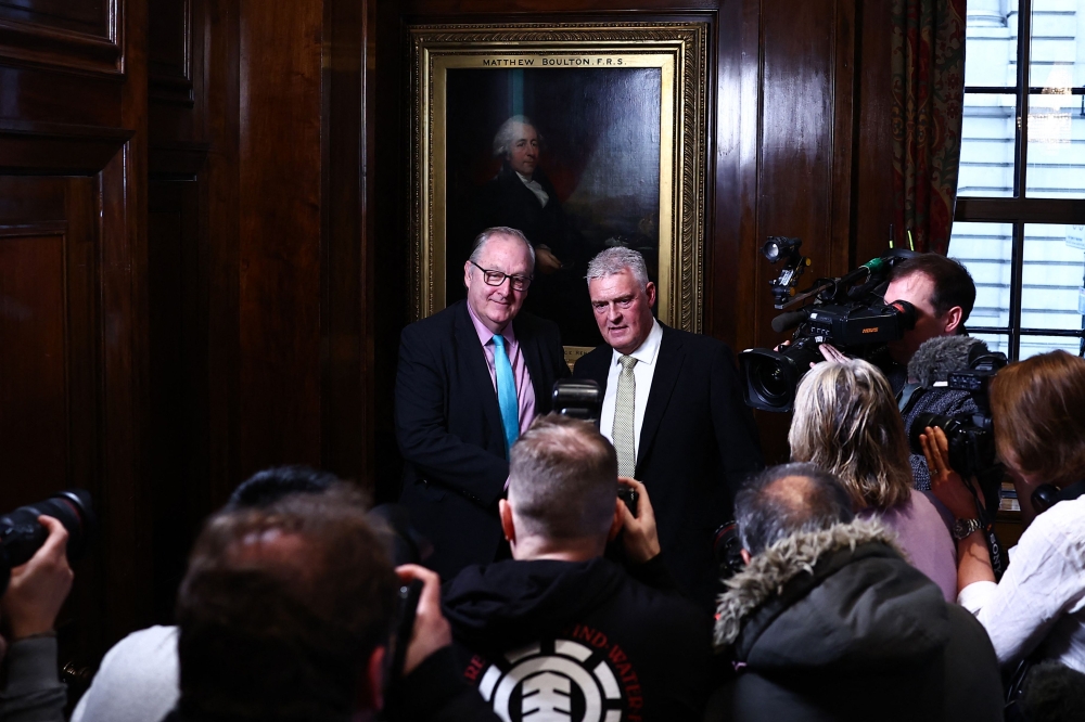 Former Conservative deputy chairman Lee Anderson (R) poses for pictures with London Mayor Candidate for Reform UK party Howard Cox following a press conference to announce his defection from the Conservative party to Reform UK, in London, on March 11, 2024. — AFP pic