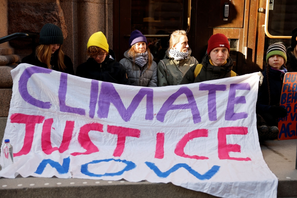 Climate activist Greta Thunberg blocks the entrance of the Swedish Parliament during a protest in Stockholm, Sweden March 11 2024. — TT News Agency via Reuters pic