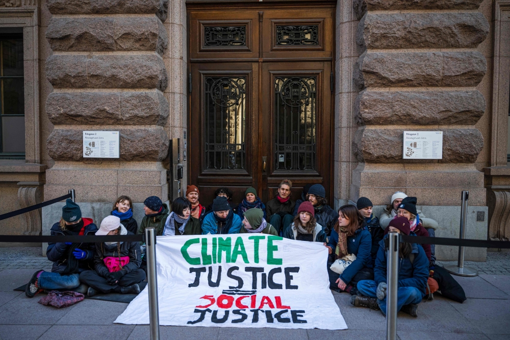 A group of climate activists block one of the entrances of the Swedish Parliament during a protest due to the lack of action from the Swedish authorities, on March 11, 2024, in Stockholm, Sweden. — AFP pic