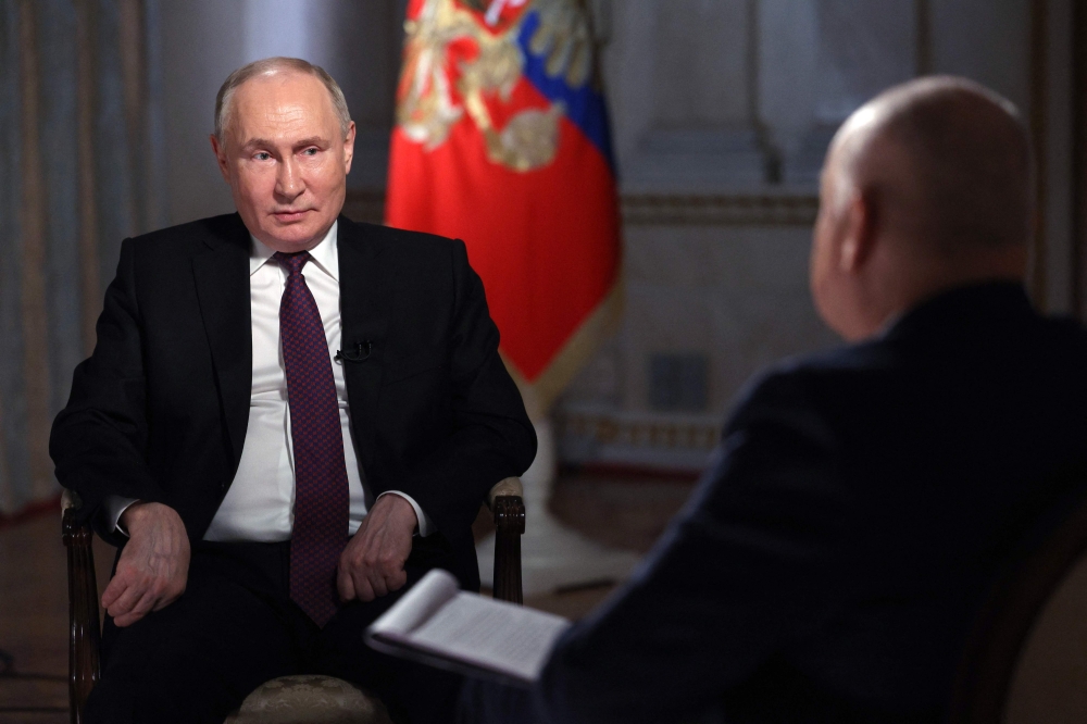 In this pool photograph distributed by Russia's state agency Sputnik, Russian President Vladimir Putin gives an interview to TV host and Director General of Rossiya Segodnya. — AFP pool pic