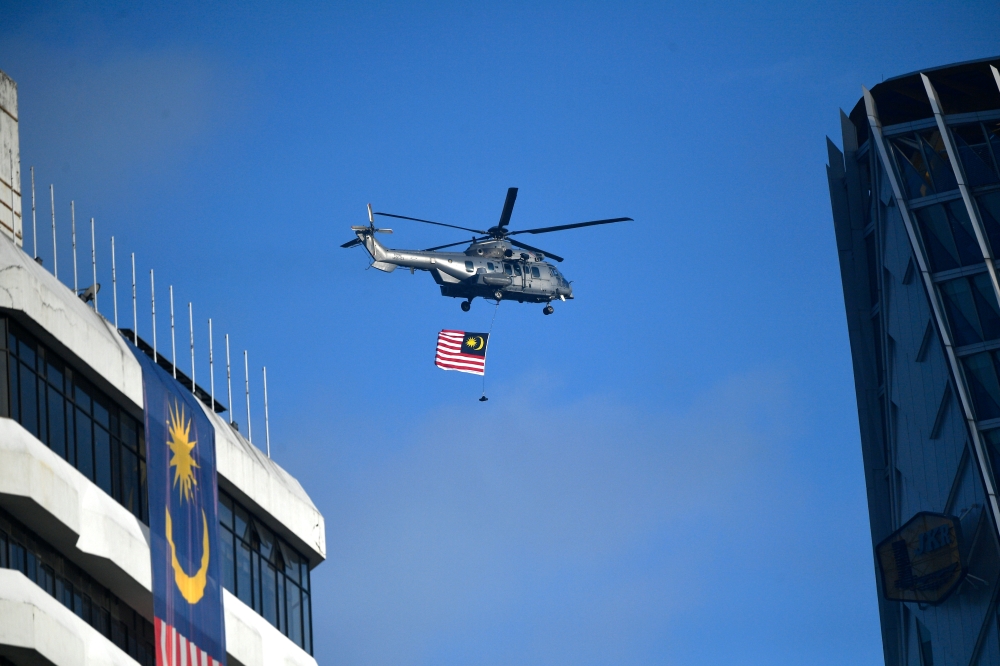 File picture of a helicopter bearing the Malaysian flag flies over Dataran Merdeka in Kuala Lumpur, August 31, 2022. The National Security Council (MKN) will conduct a helicopter landing exercise at the landing points of Bangunan Perdana Putra and Seri Perdana Complex here, for two days starting tomorrow. — Bernama pic