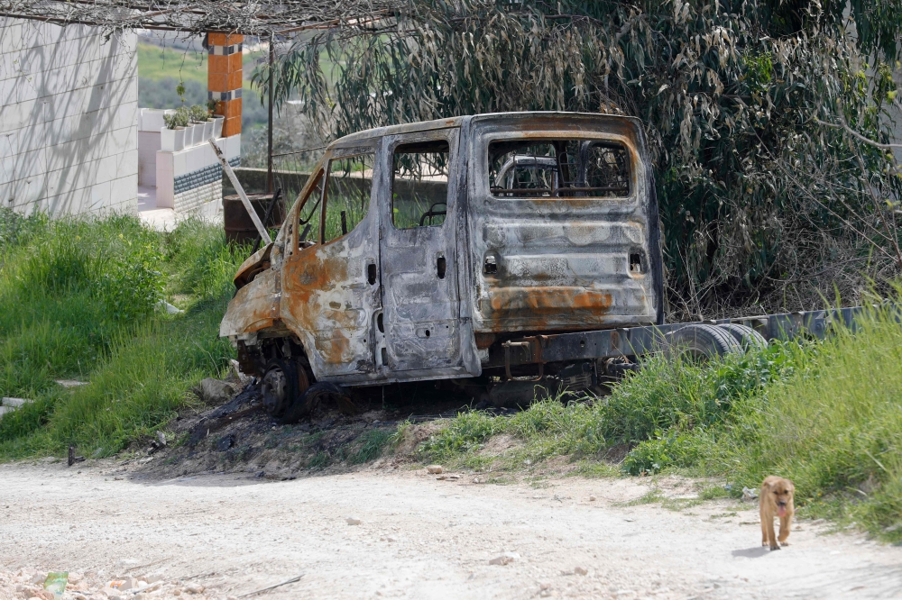 The burnt carcass of a truck destroyed in an Israeli settler attack rusts on the roadside in Huwara town in the occupied West Bank on March 13, 2024. — AFP pic