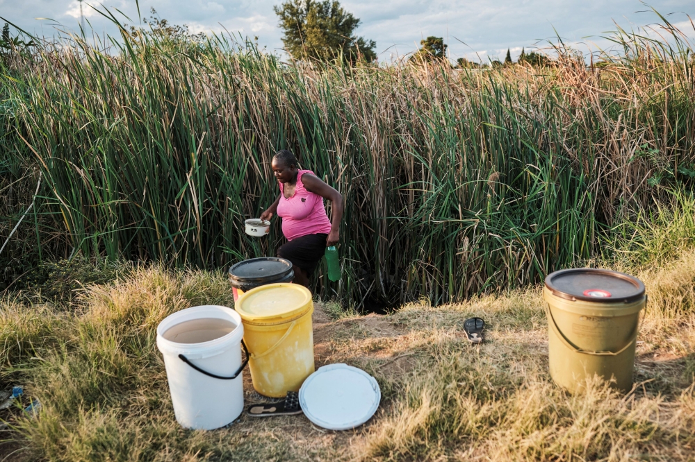 A woman gathers water from a shallow well near a river, as temperatures soar during the El Nino-related heatwave and drought affecting a large part of the country in Bulawayo, Zimbabwe March 7, 2024. — Reuters pic