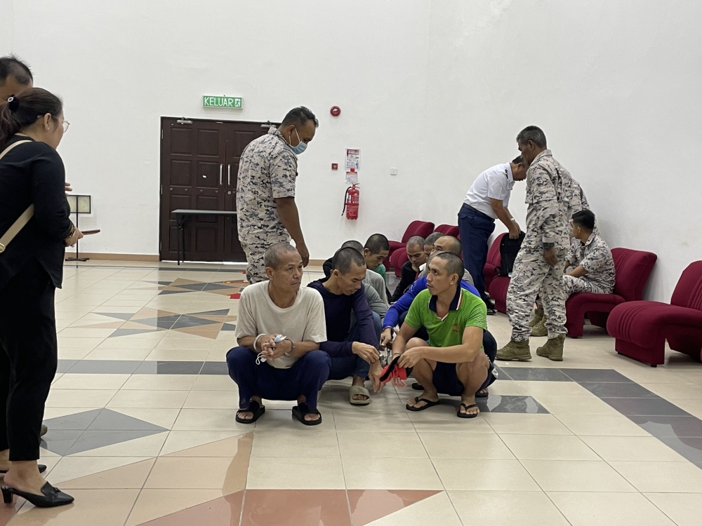 The Vietnamese fishermen are seen at the Kuching Court Complex after sentencing today. — The Borneo Post pic