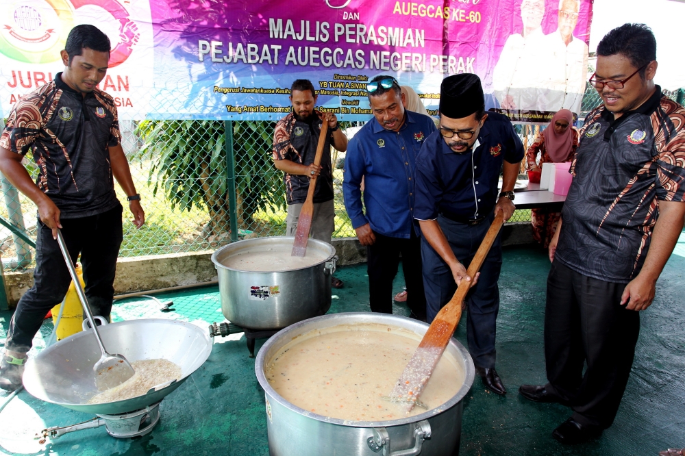 Cuepacs president Datuk Adnan Mat (second, right) stirs bubur lambuk at the AUEGCAS Perak bubur lambuk programme at the AUEGCAS Perak Office, Ipoh, March 15, 2024. — Bernama pic 