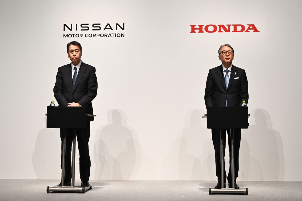 Makoto Uchida, president and CEO of Nissan (left) and Toshihiro Mibe, Honda director, president and representative executive officer attend a joint press conference in Tokyo on March 15, 2024. — AFP pic