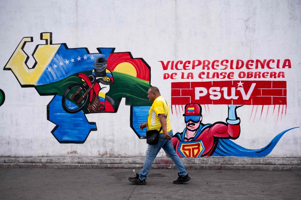 A man walks pass a mural painted with the comic character ‘Super Bigote’ (Super Mustache), inspired in Venezuelan President Nicolas Maduro, in Caracas on March 12, 2024. — AFP pic