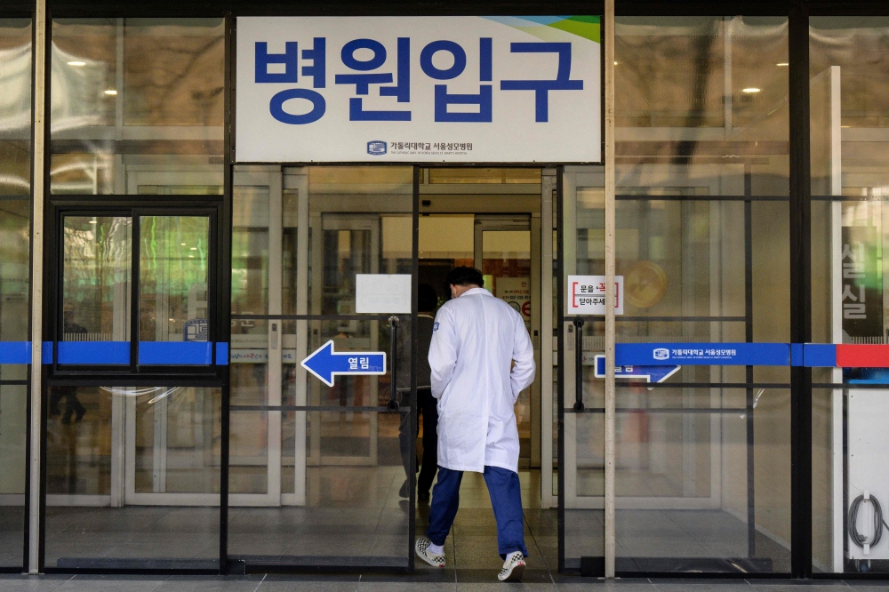 A medical worker walks into a hospital in Seoul on March 15, 2024. Thousands of trainee medics walked off the job on February 20 to protest government plans to sharply increase the number of doctors, which it says is essential to combat shortages and serve South Korea’s rapidly ageing population. — AFP pic