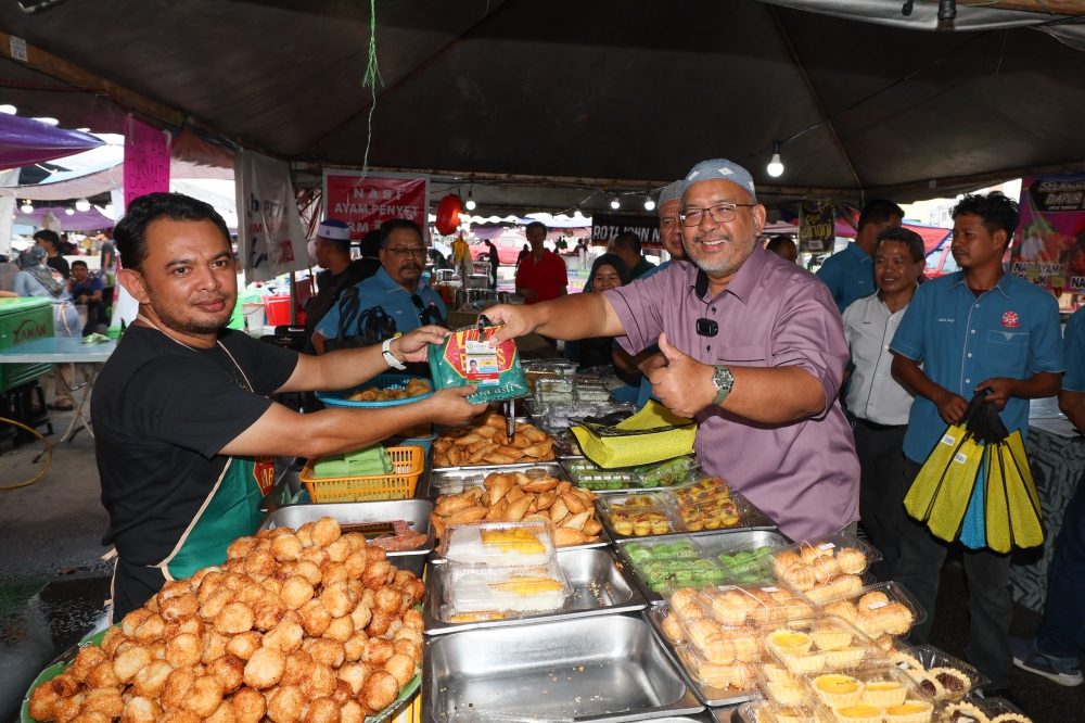 Terengganu Housing and Local Government Committee chairman Wan Sukairi Wan Abdullah (3rd right) hands over aprons and certificate cards to bazaar traders during a survey at the Taman Shahbandar Ramadan Bazaar March 16, 2024. — Bernama pic