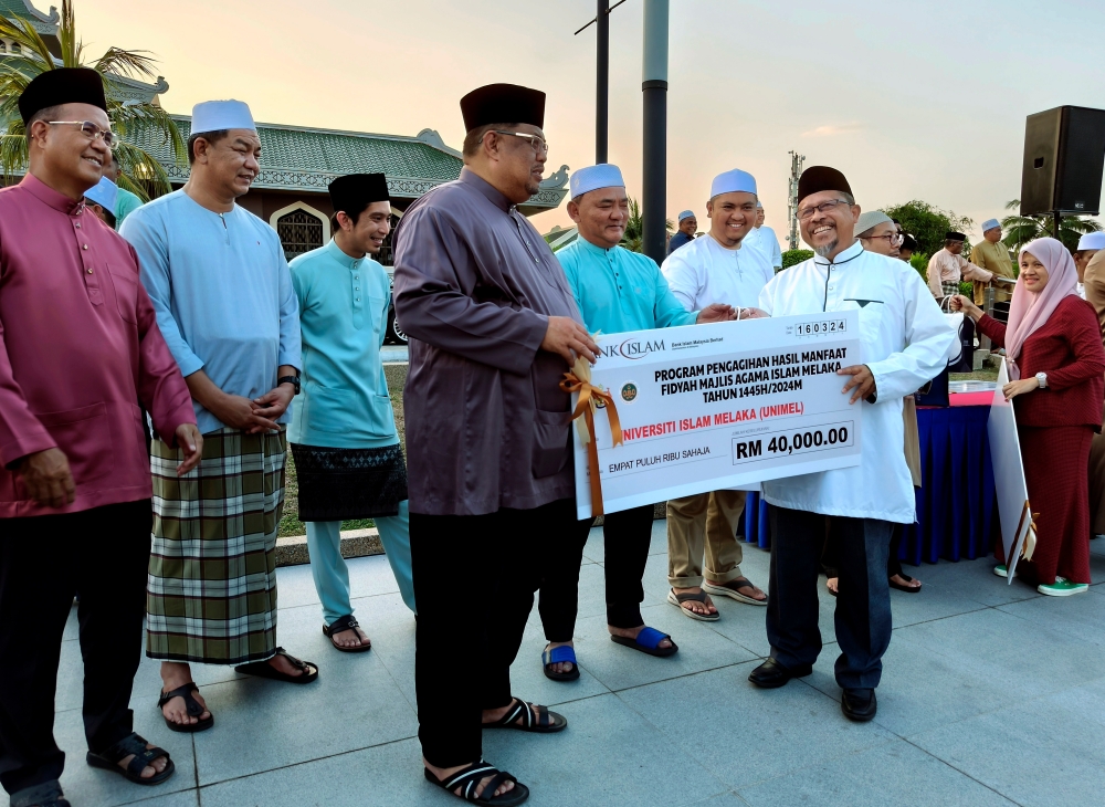 Melaka Chief Minister Datuk Seri Ab Rauf Yusoh (3rd left) presents the contribution for 28 registered tahfiz institutions to Universiti Islam Melaka Vice Chancellor Prof Datuk Mohd Taib Dora (front, right) at Dataran Pusat Islam Melaka March 16, 2024. — Bernama pic