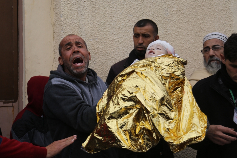 Palestinians mourn at the Al-Aqsa Martyrs Hospital in Deir al-Balah next to bodies of victims pulled from the rubble of the Tabatibi family home on March 16, 2024, following overnight Israeli bombardment. — AFP pic
