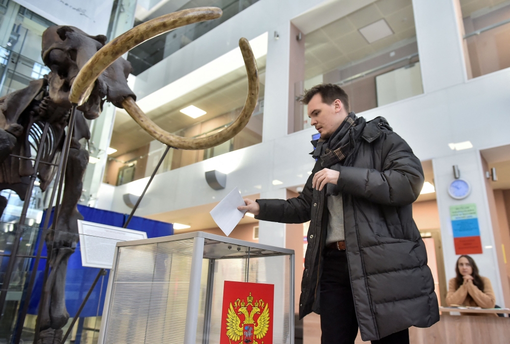 A man casts his ballot near a giant mammoth skeleton at a polling station located in Novosibirsk State University, on the final day of the presidential election in Novosibirsk, Russia, March 17, 2024. — Reuters pic