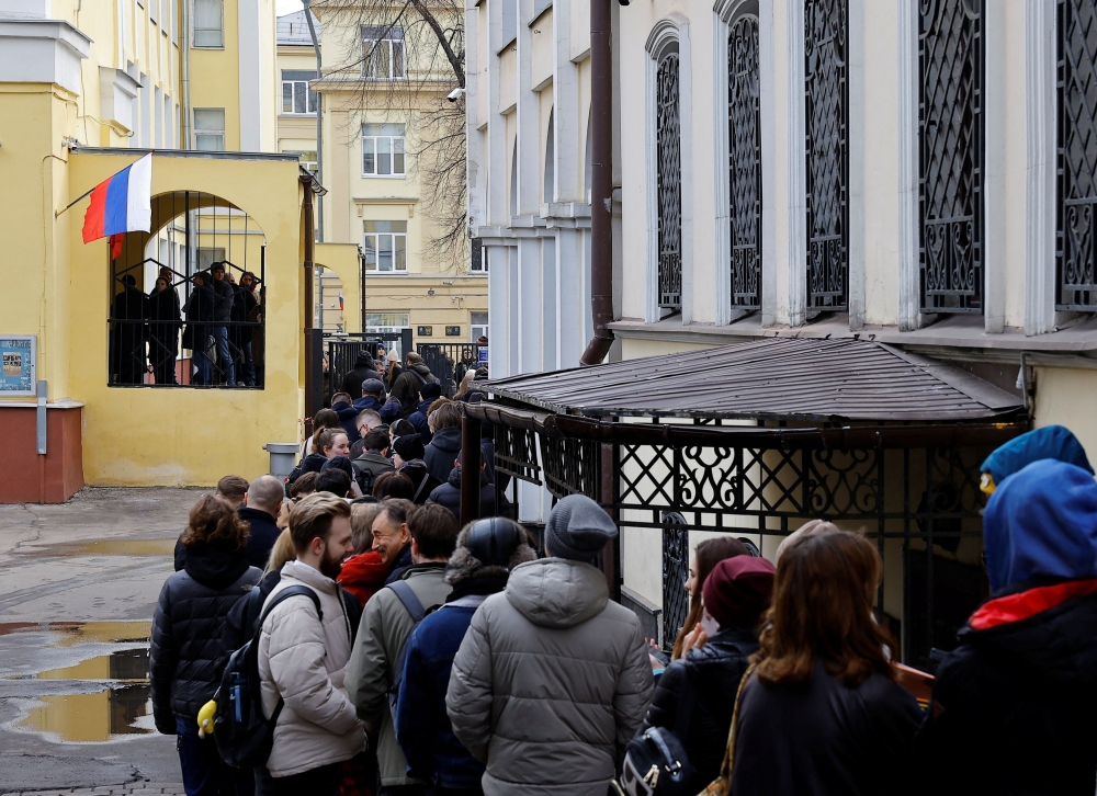 People stand in a line to enter a polling station after noon on the final day of the presidential election in Moscow, Russia, March 17, 2024. — Reuters pic