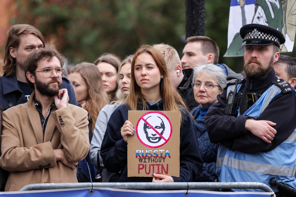 A person holds a placard against incumbent Russian President Vladimir Putin, on the final day of the presidential election in Russia, amid Russia's attack on Ukraine, near the Russian Embassy, in London, Britain, March 17, 2024. — Reuters pic