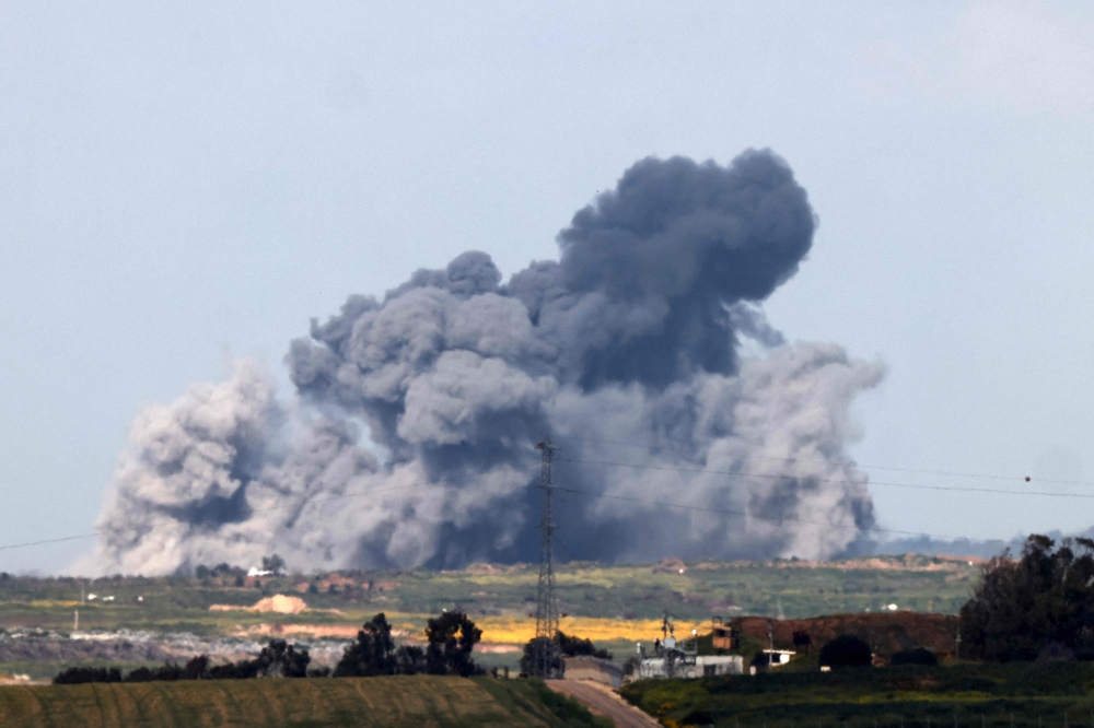 This picture taken from southern Israel shows smoke billowing over the Gaza Strip during another Israeli bombardment. — AFP pic