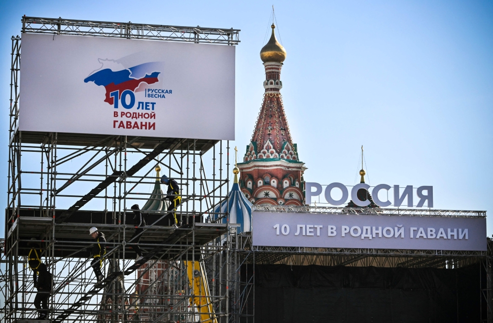 Workers ready a stage for a concert marking the 10th anniversary of Russia’s annexation of Crimea in downtown Moscow. — AFP pic
