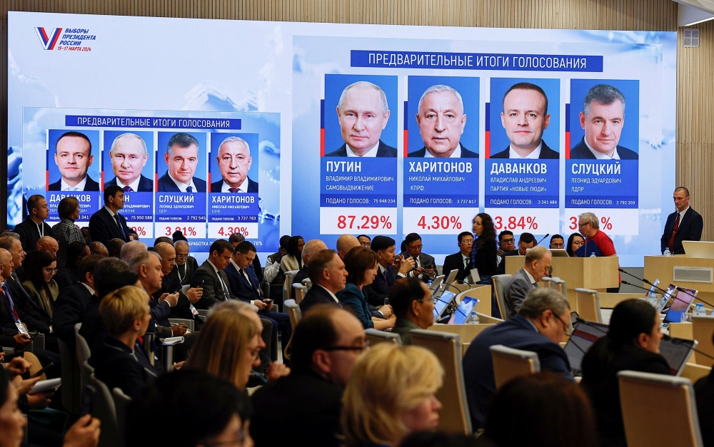 Officials and journalists sit near a screen showing the preliminary results of Russia's presidential election as they attend a press conference of Ella Pamfilova, Chairwoman of the Central Election Commission, who announces preliminary results at the commission's headquarters in Moscow, Russia, March 18, 2024. — Reuters pic