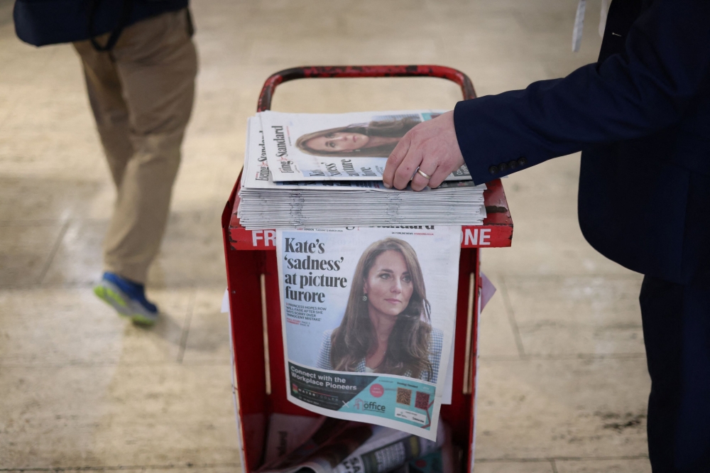 A commuter picks up a copy of the Evening Standard featuring a picture of Britain’s Catherine, Princess of Wales, on the front page at subway station in London, Britain, March 12, 2024. — Reuters pic