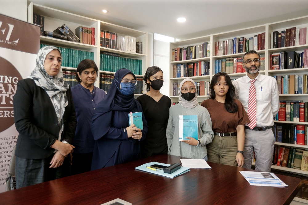 Lawyers For Liberty executive chairman Latheefa Koya (first from left), lawyer Datuk S. Ambiga (second from left) and Legal Advisor N. Surendran (first from right) take a group photo with Seri Mulyati Syamsudin (third from left), Wiwin Handayani (centre), Khairunnisa Ibrahim (third from right) and Vanessa (second from right), during a press conference at the Lawyers For Liberty office in Petaling Jaya March 19, 2024. 