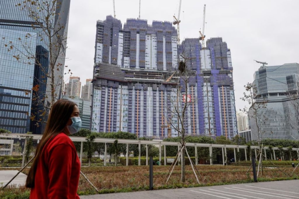 A woman walks in front of an under-construction residential building, in Hong Kong, China, February 27, 2024. — Reuters pic